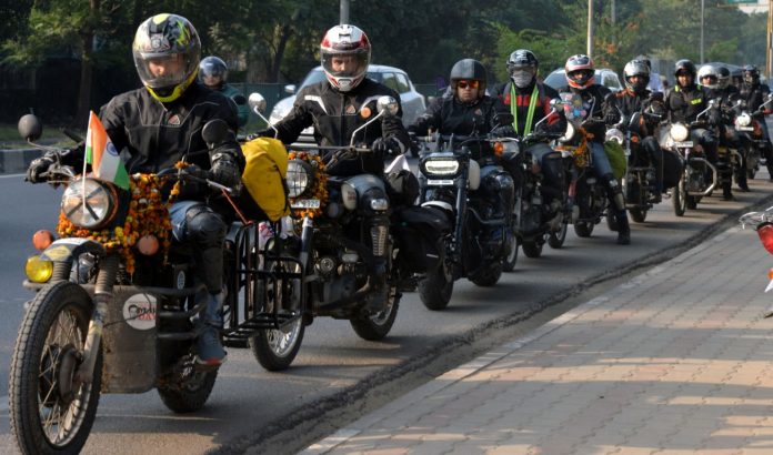 Youngsters on motor bikes spend time with dairy farmers at Rangarh Village